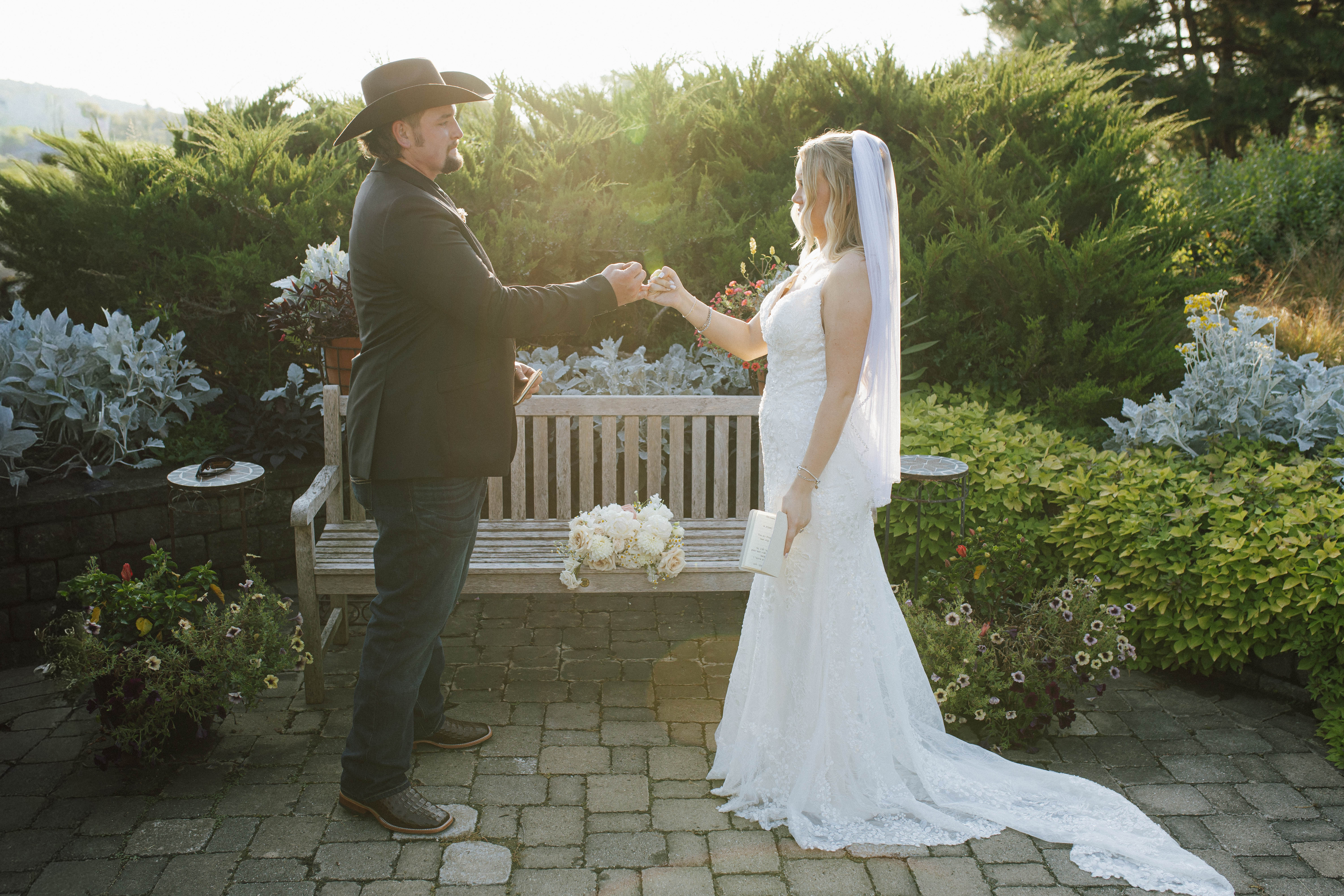 Wisconsin wedding photographer - bride and groom first look moment in garden with white florals holding hands at sunset