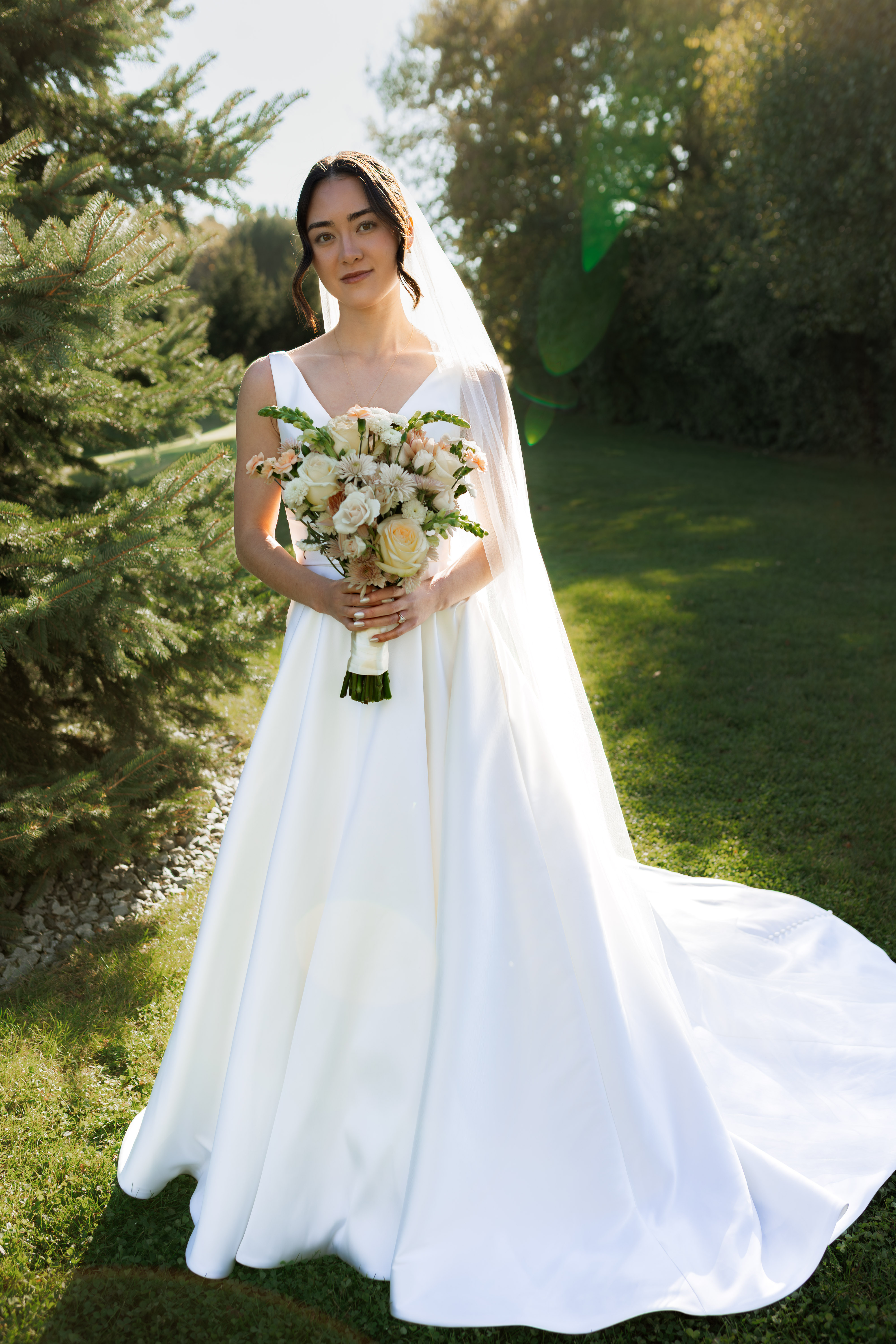 Elegant bride portrait on garden path with cream and peach bouquet
