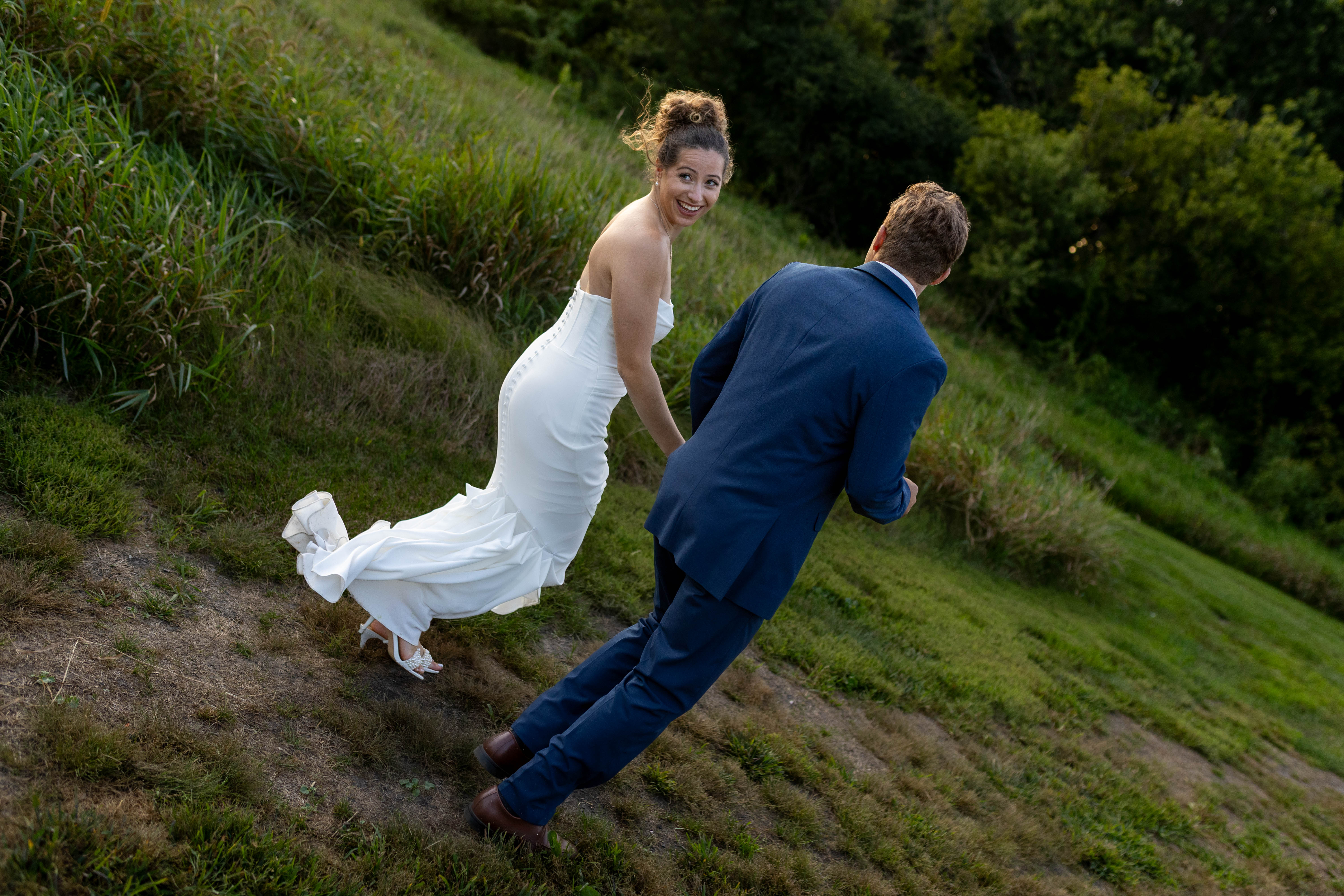 Candid bride smiling walking up hillside